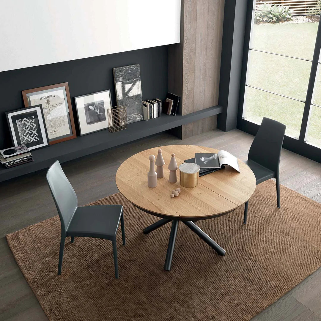 Top view of circular expanding dining table with two chairs set up.