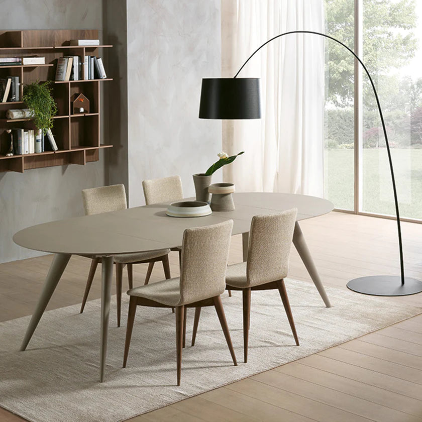 Round dining table extended to oval shape, set up for 6 people.