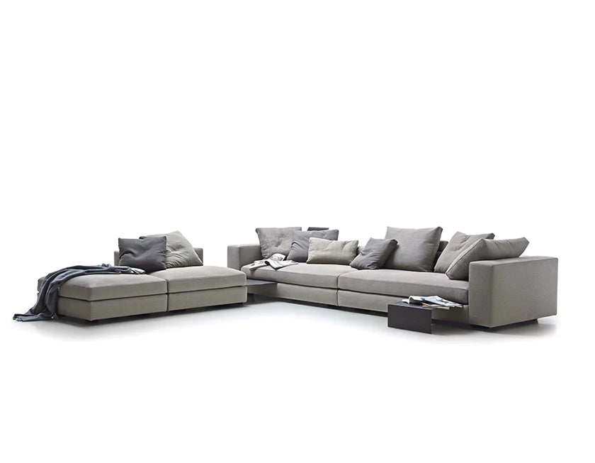 Sectional sofa configuration with pull out tables and cushions scattered on the seats.