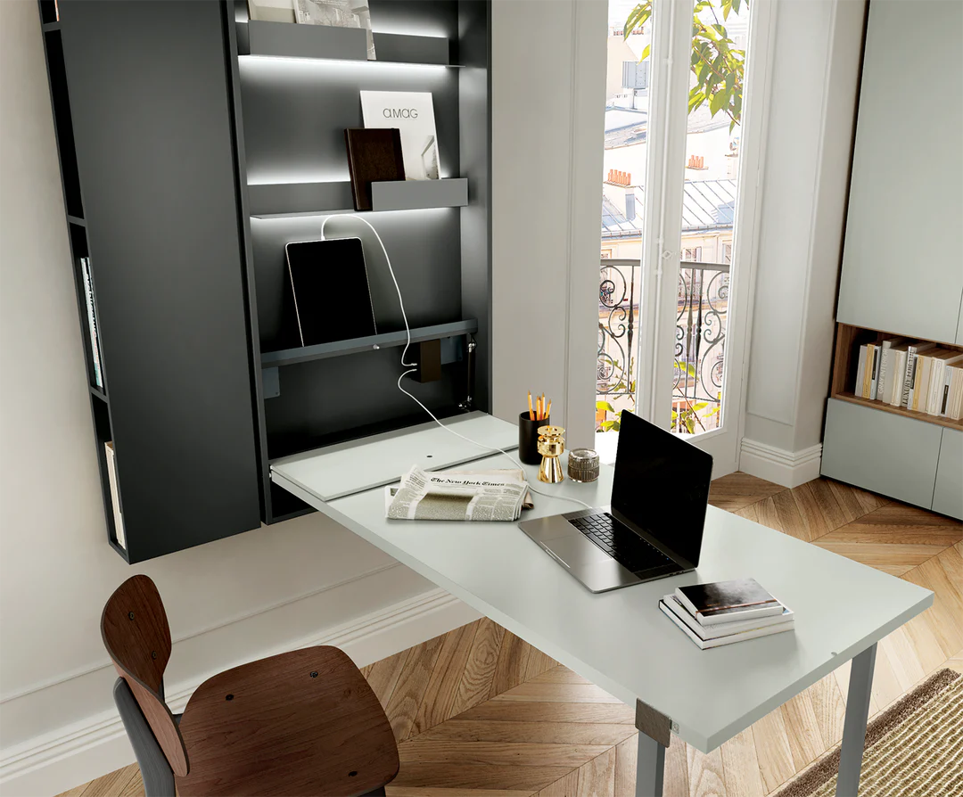 Close up of the Wally desk open with computer atop the table, and electronics stacked inside the structure on the integrated shelving.