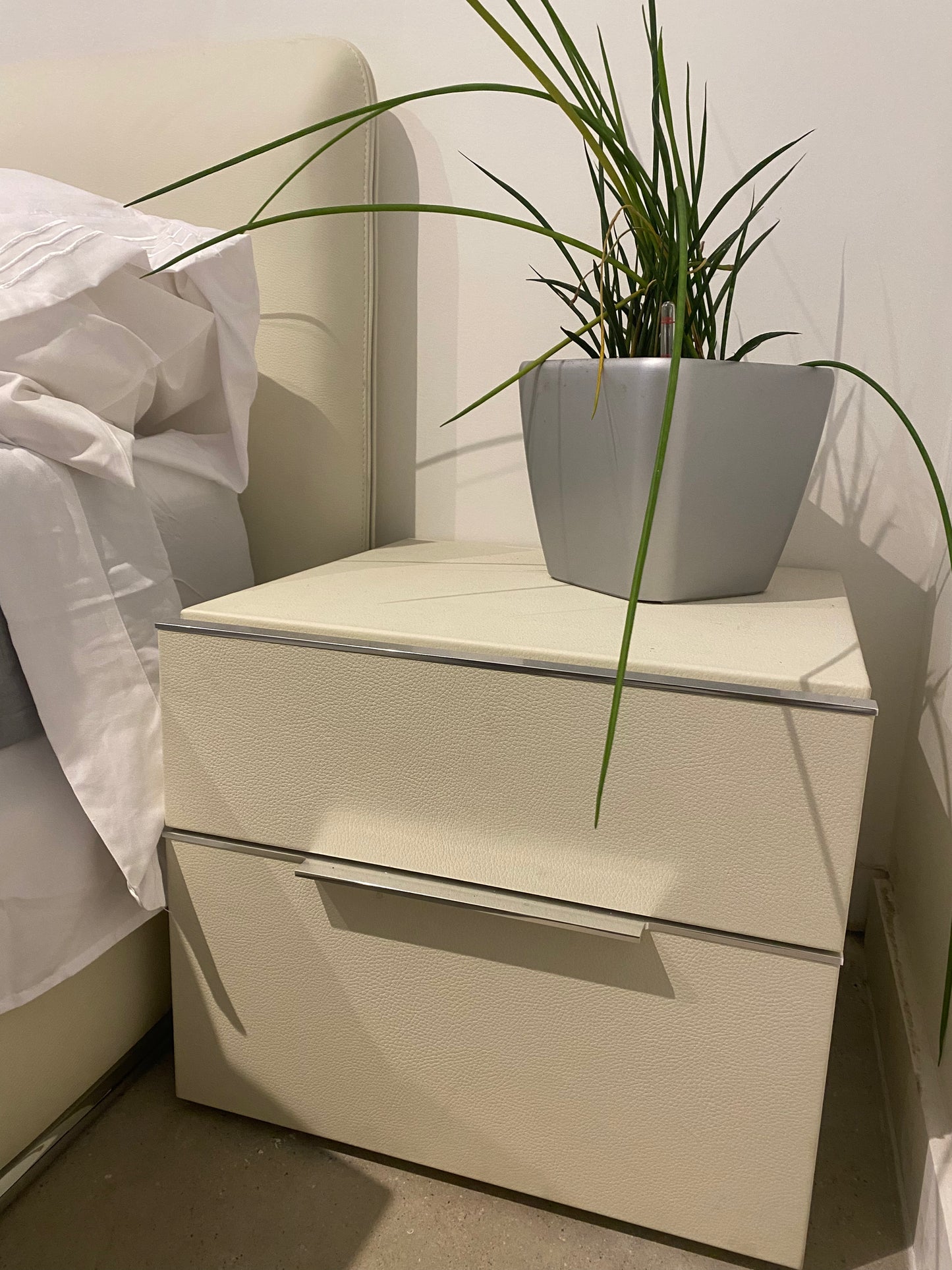 Nightstand with chrome handles and plat atop it