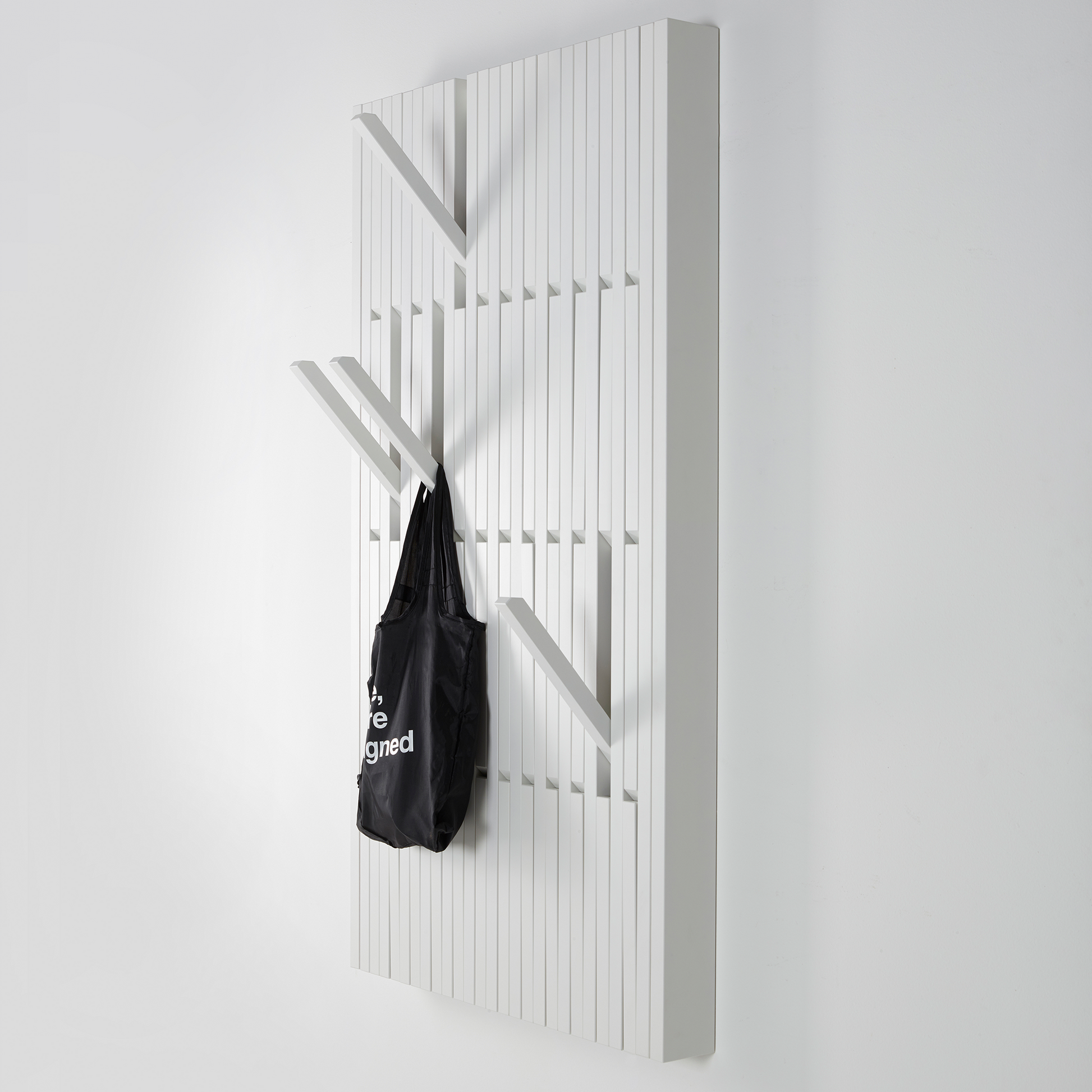 White wooden wall hanger, with bag hanging to it.
