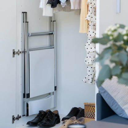 Folding dining chairs on wall mounted hook for storage.