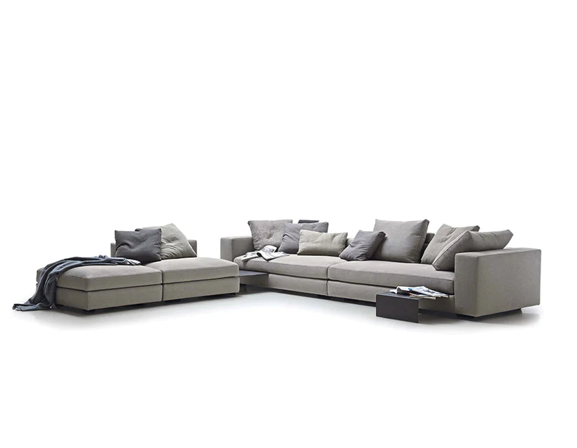 Sectional sofa configuration with pull out tables and cushions scattered on the seats.