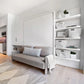 Custom shelving unit finished in lacquer, next to wall bed with sofa.