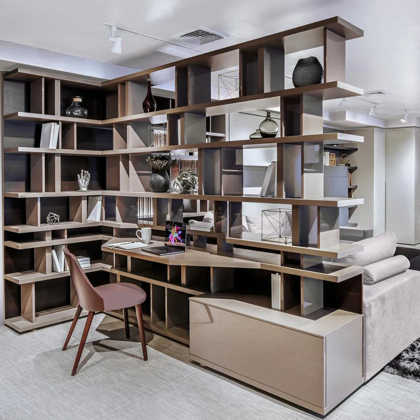 Floor to ceiling custom shelving unit, used as a room divider and home office.