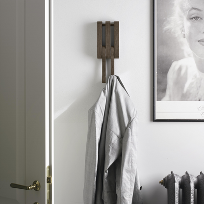 Shirt hanging off wooden wall hook.