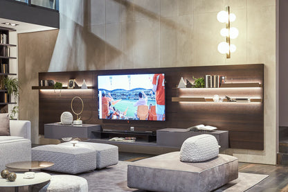 Wall mounted media unit in living room setting. LED lights below metal shelves elevate the appearance whilst lower floating storage containers house accessories.